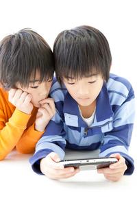 二人の男の子がゲーム機で遊んでいる様子